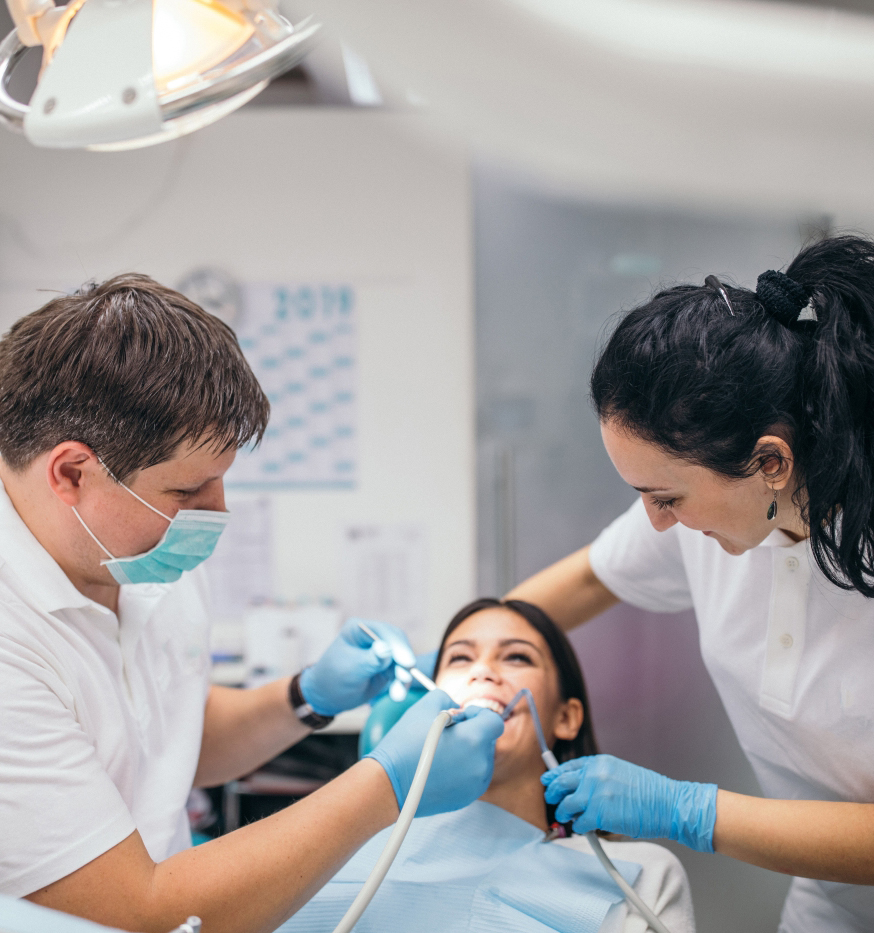 Two people doing dental work on third person