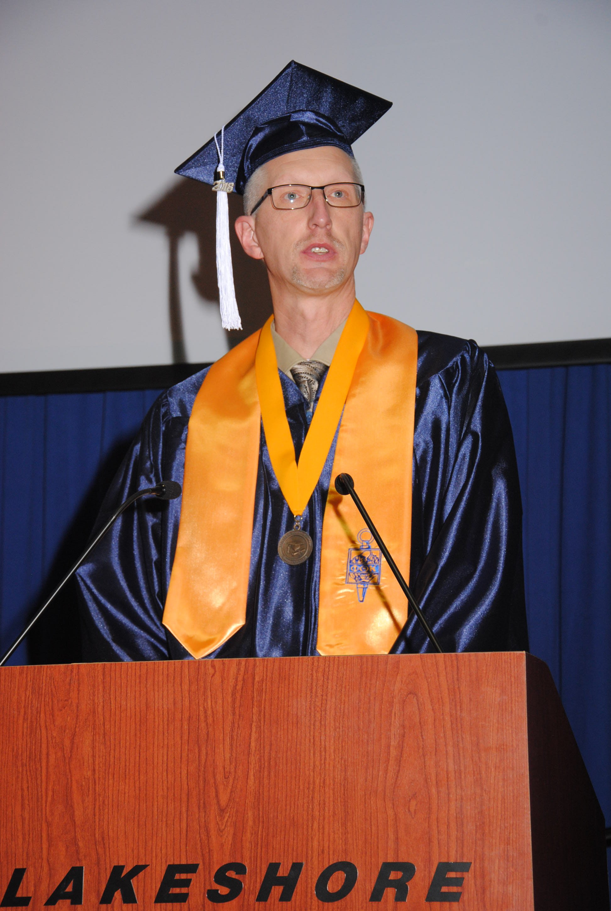 Student speaker Darin Menk encourages graduates to stand tall as they embark on their careers